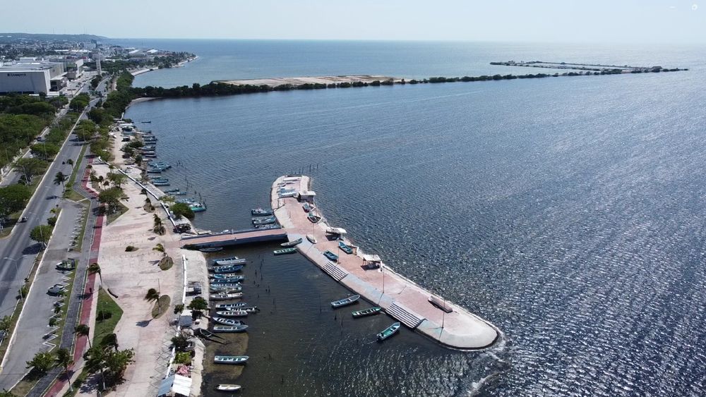 Explanada pavimentada y paseo costero junto a un muelle